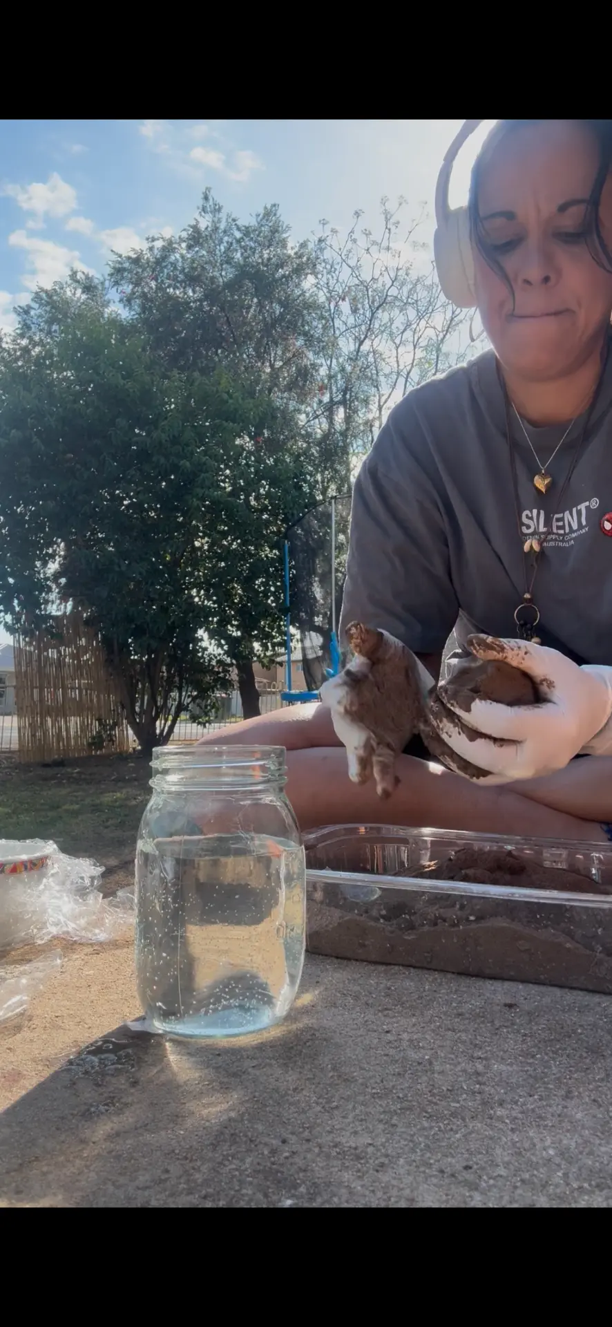 Yoorana shaping a Dhawun Buru by hand with a jar of water