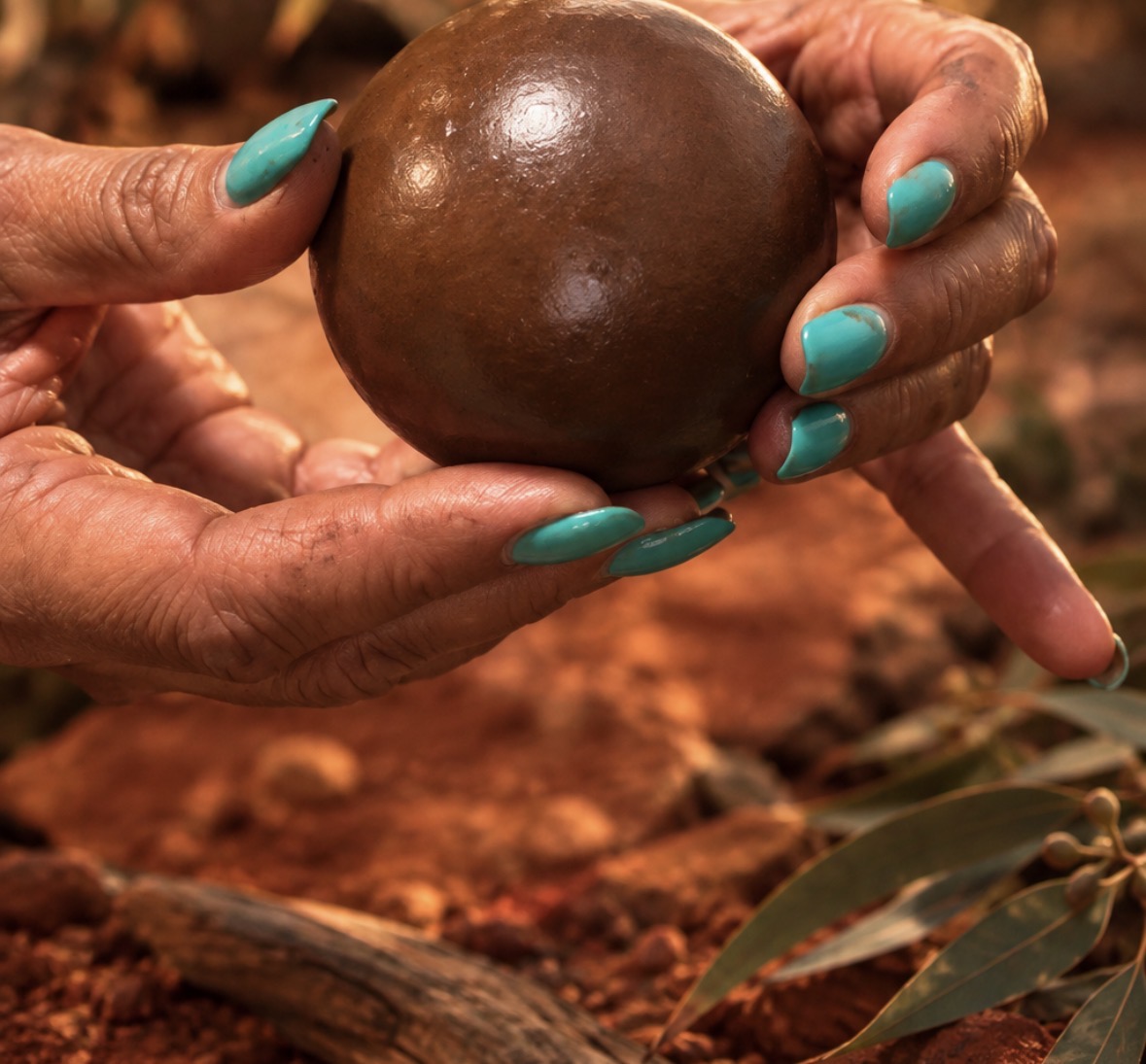 A polished Dhawun Buru held carefully in two hands